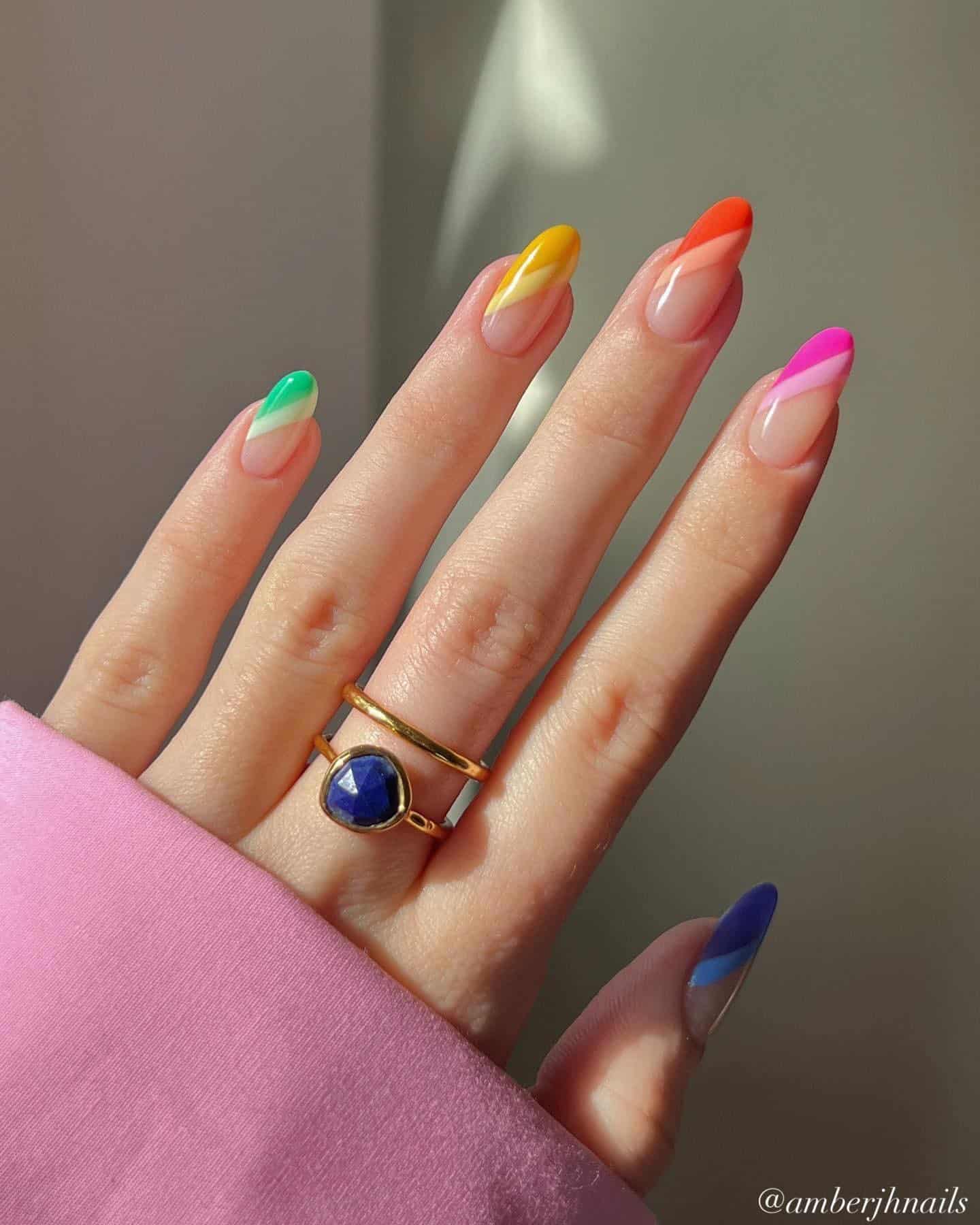 A hand with medium round nails painted with gradient asymmetrical French tips