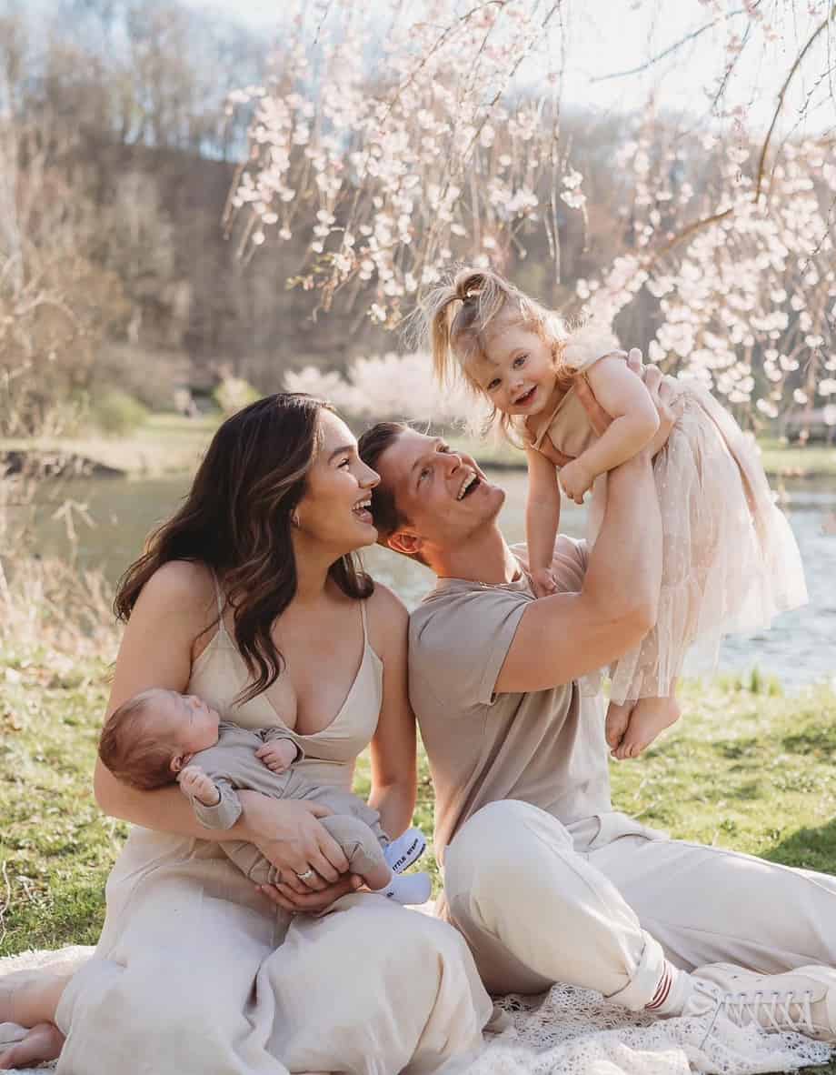 An image of a summer family portrait with four family members wearing beige and nude toned clothing