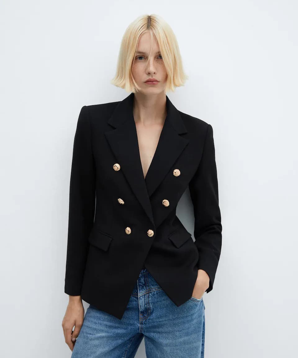 woman wearing a black double breasted blazer with gold buttons