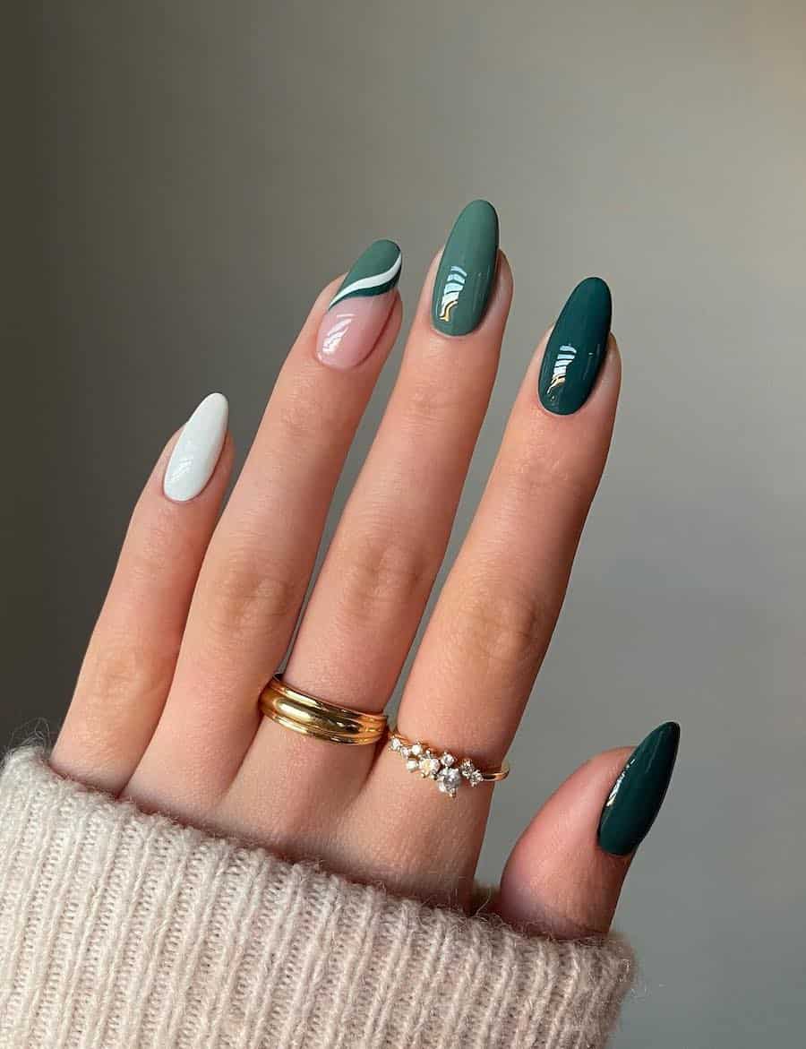 a hand with medium-length almond nails painted in white and two shades of green with a wave detailed accent nail