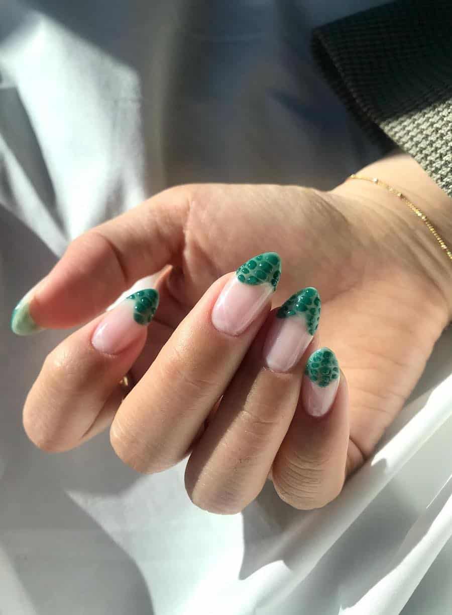 a hand with medium length glossy nude nails with wavy forest green French tips with textured details