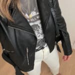 woman wearing a black leather jacket, graphic t-shirt, off-white jeans and black loafers as a fall capsule wardrobe outfit