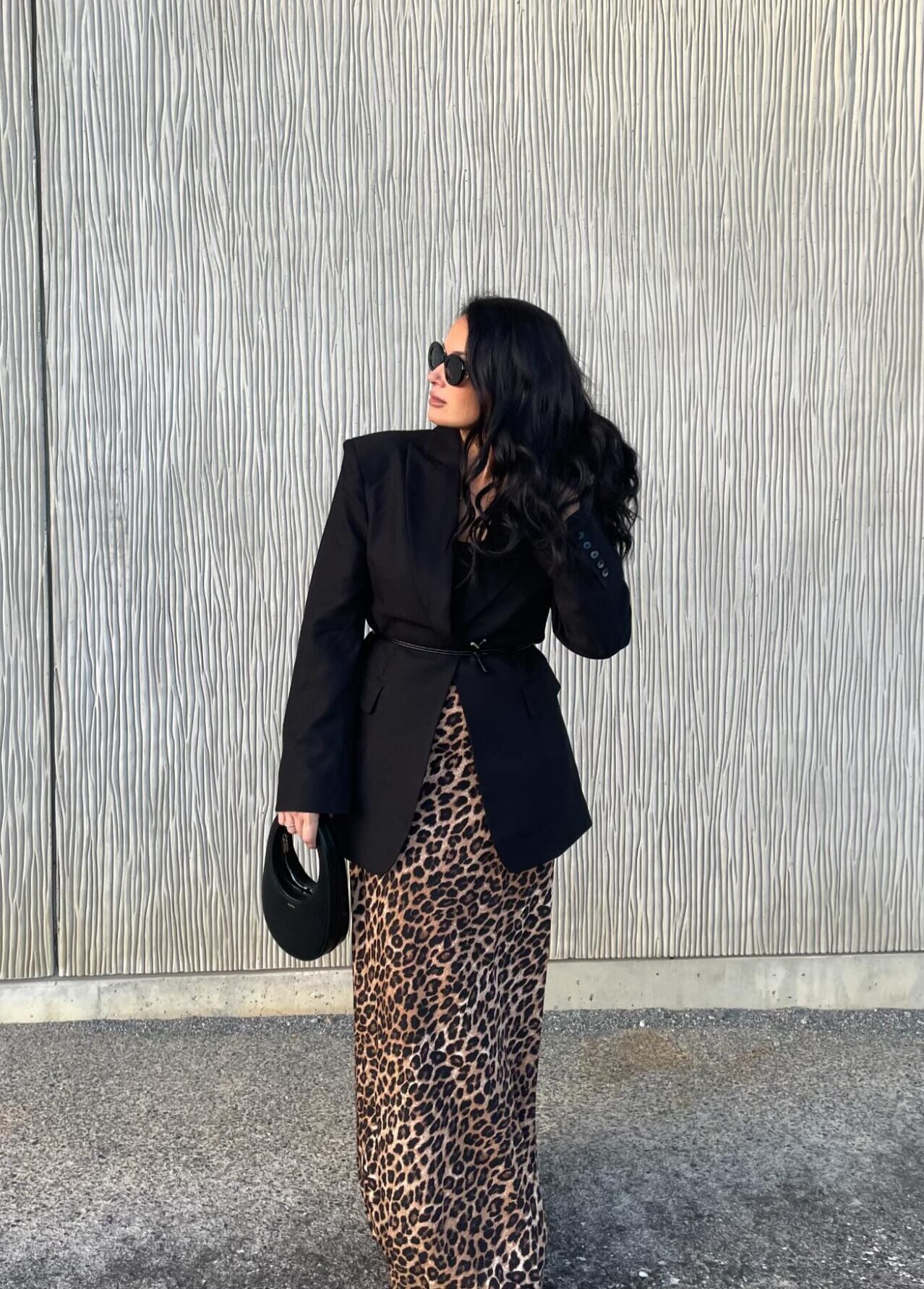 woman wearing an oversized black blazer over a leopard slip dress