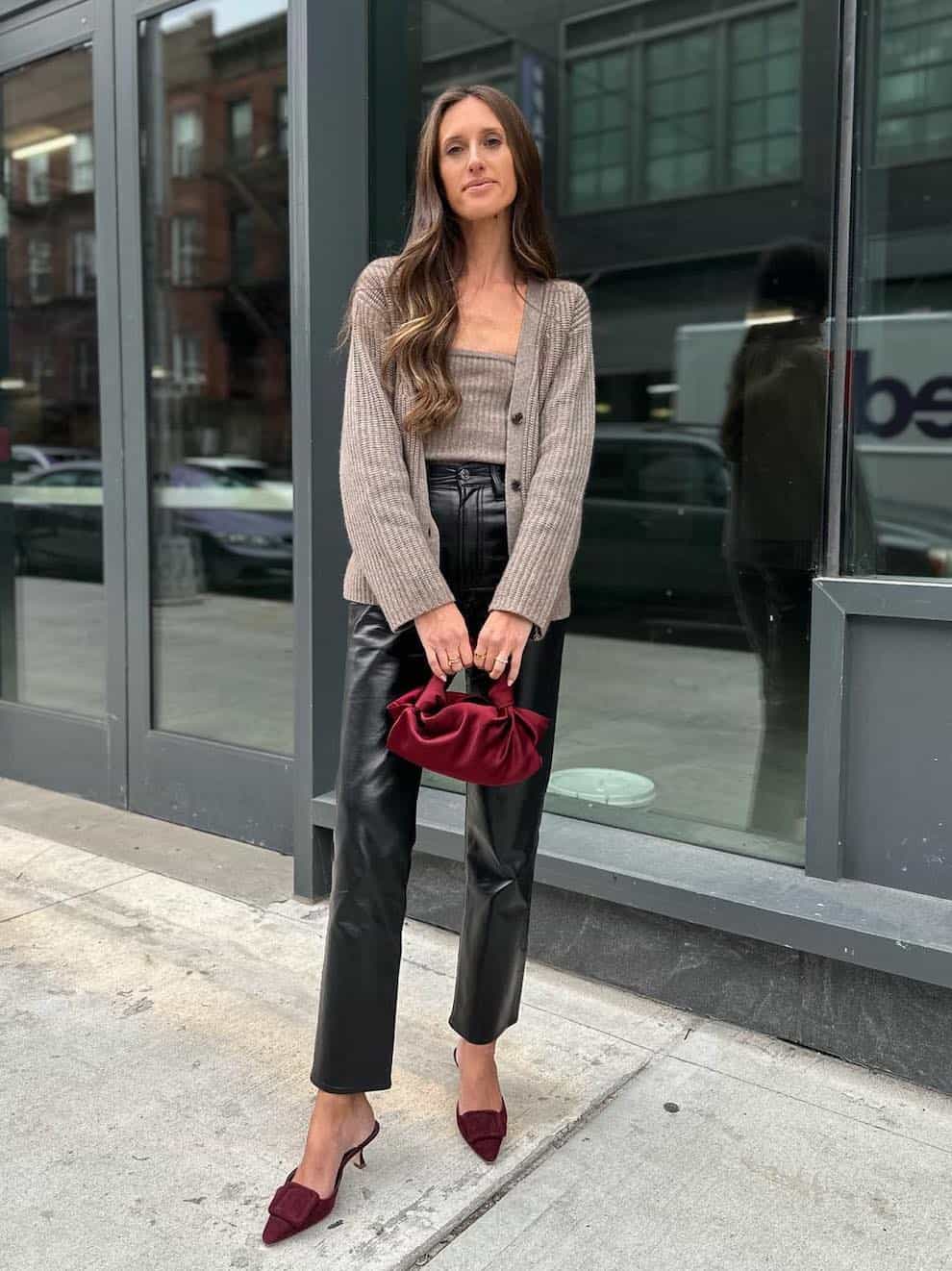 woman wearing a knit tank and cardigan set with leather pants and wine colored pumps for a fall date night outfit