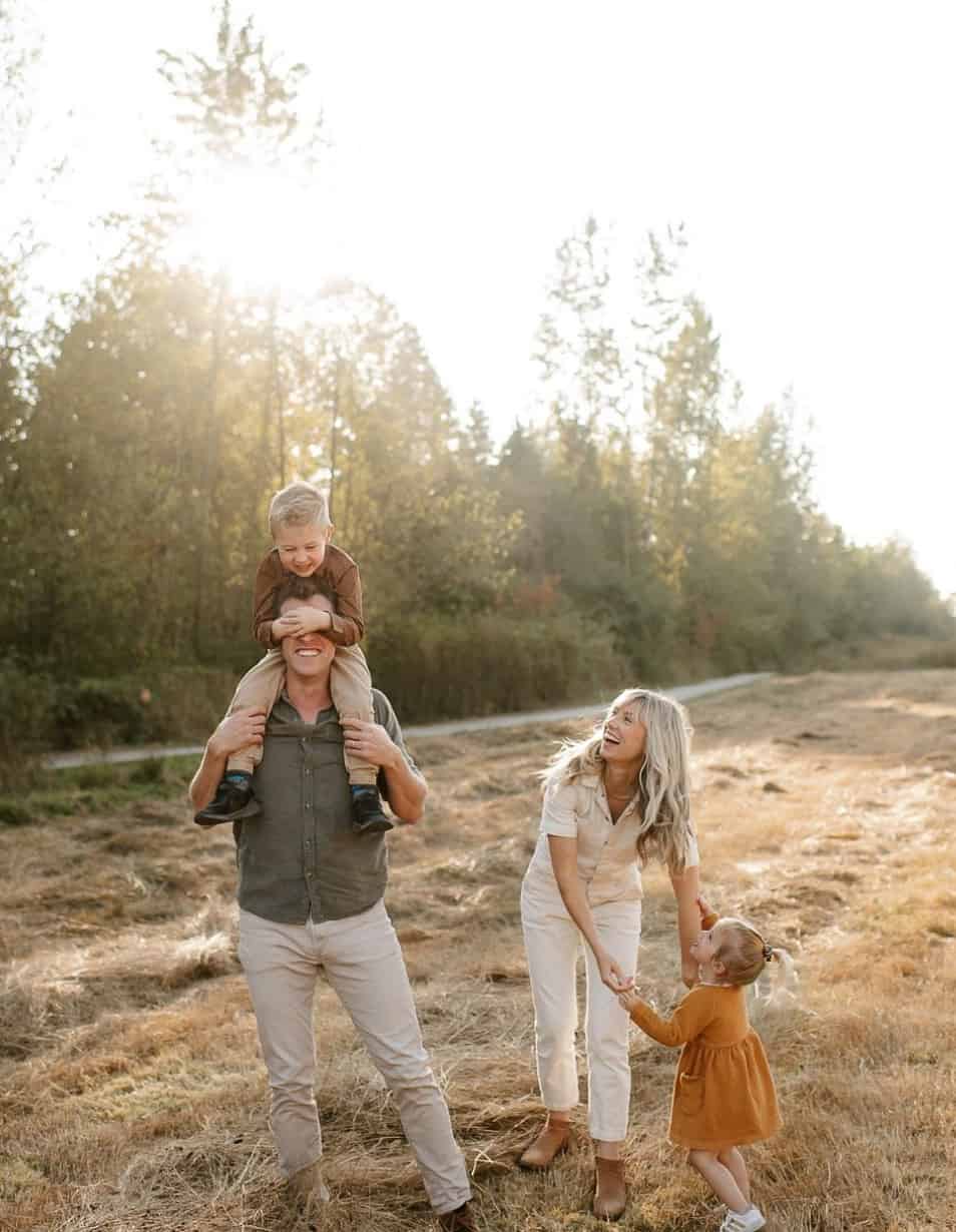 family having an outdoor fall photoshoot wearing neutrals, green, and burnt orange