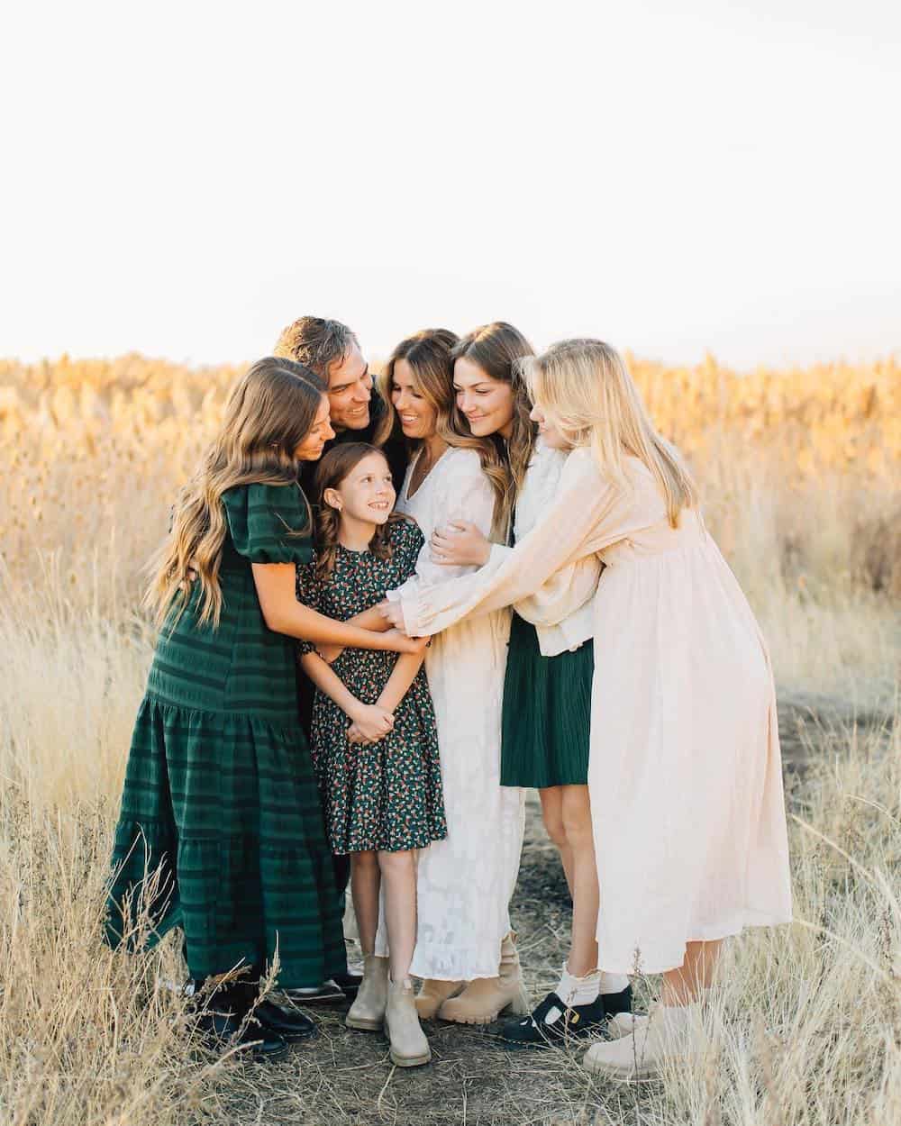 image of a family having an outdoor fall photoshoot wearing a mix of cream and forest green