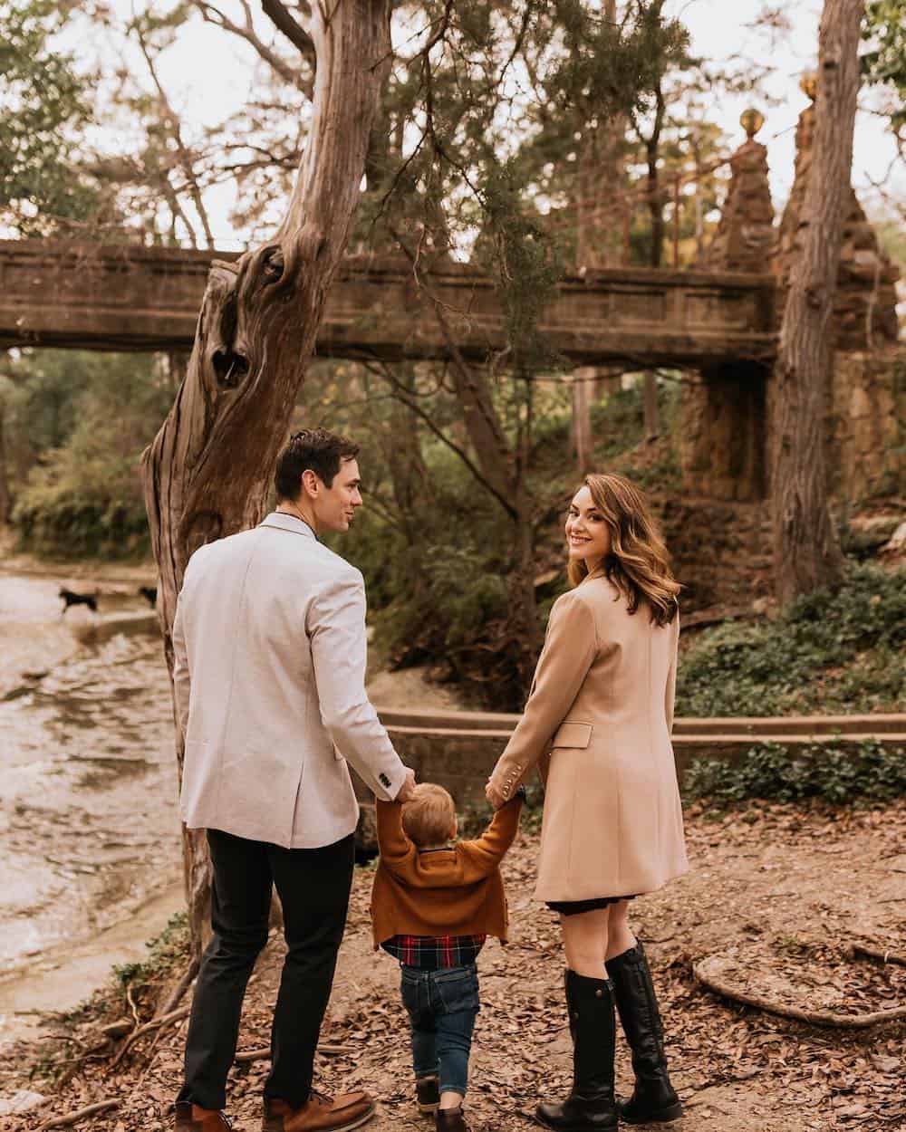 image of a family having an outdoor fall photoshoot with a mom, dad, and small boy, all wearing neutral colors