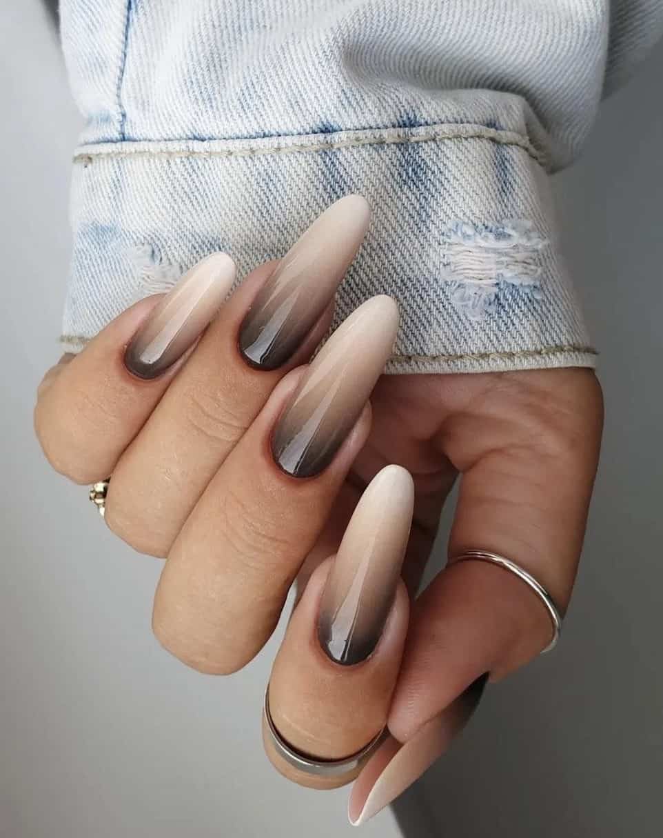 a hand with long almond nails painted a white, beige, and brown ombre