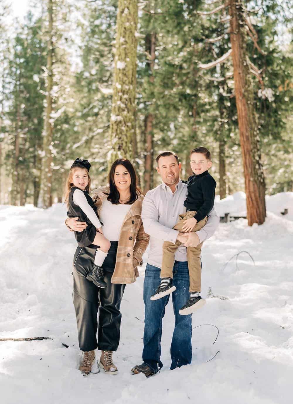 winter family photoshoot with the family wearing black, white, and beige neutral colors