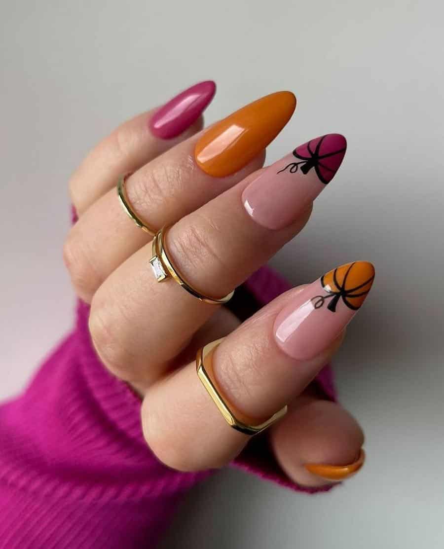 a hand with long almond nails painted orange and fuchsia with two pumpkin art French tip accent nails