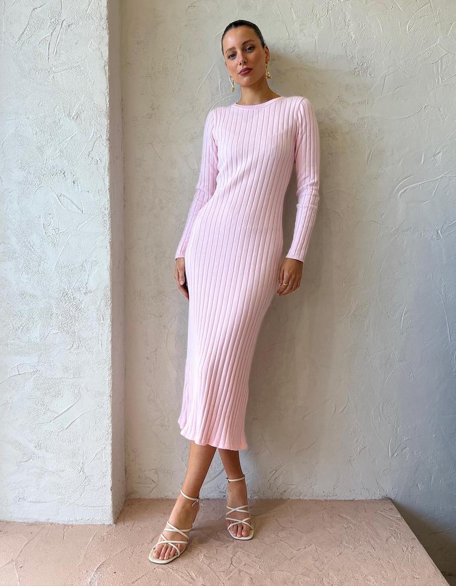 woman wearing a long baby pink sweater dress with white heeled sandals