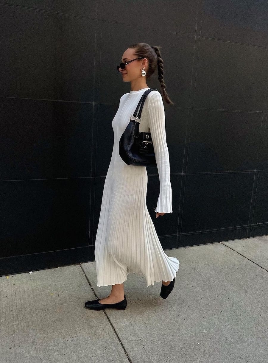 woman wearing a long ivory sweater dress with black mules