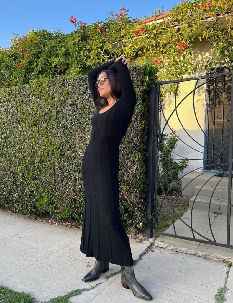 woman wearing a long maxi black sweater dress with greyish black cowboy boots