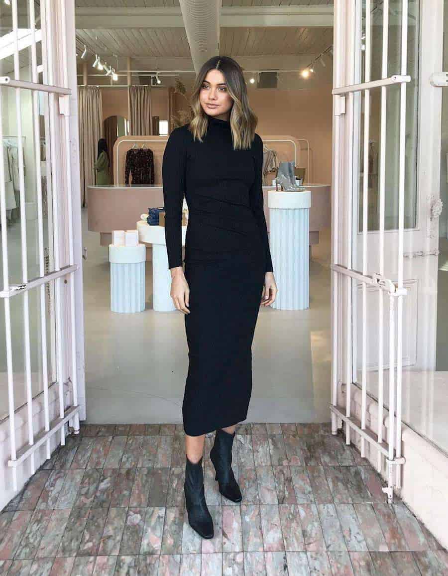 woman wearing black midi sweater dress with black glove boots