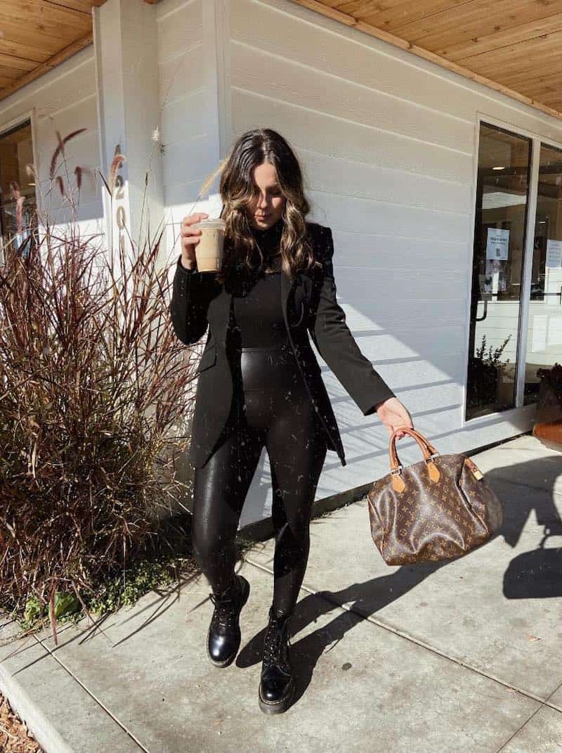 woman wearing a black blazer over a black top with black faux leather leggings and black combat boots