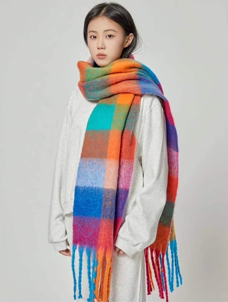 A multi-colored plaid Acne Studios scarf dupe from Etsy with fringed ends