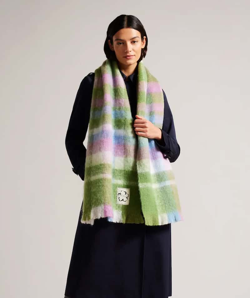 A pink, blue, purple, and green plaid Acne Studios scarf dupe from Ted Baker with fringed ends
