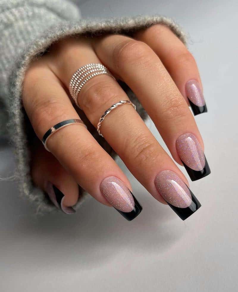 Black square french manicure with silver sparkle nail beds.