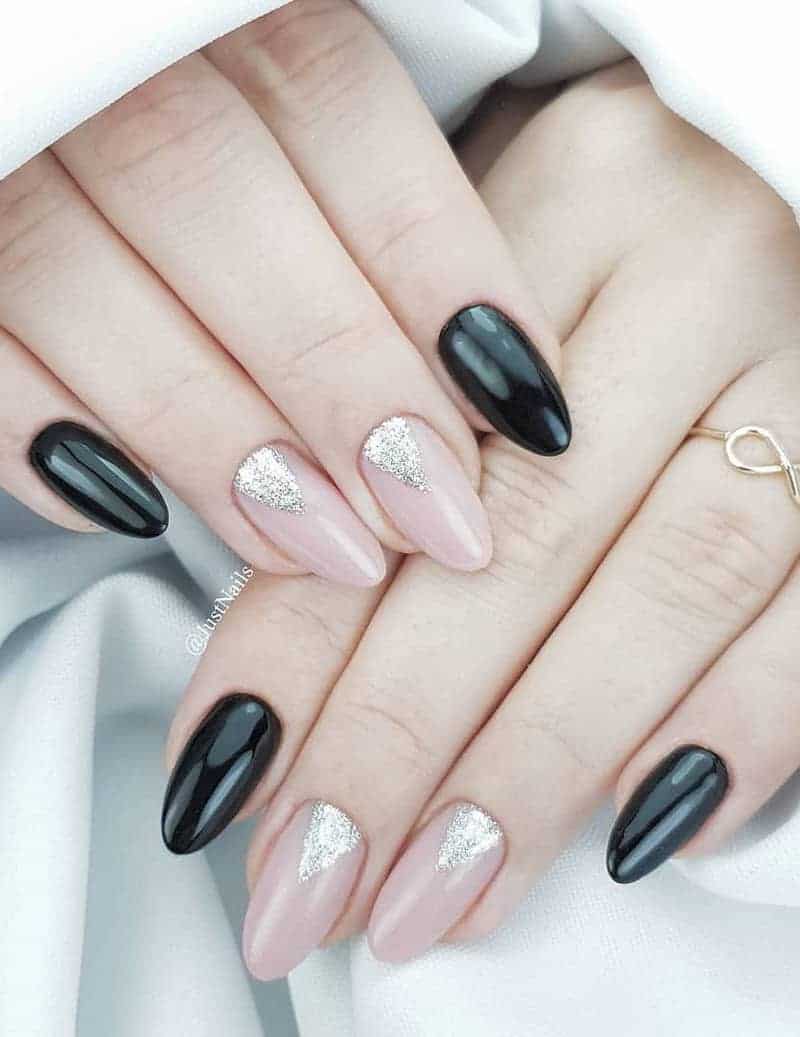 Black and nude nails with silver glitter triangle details.