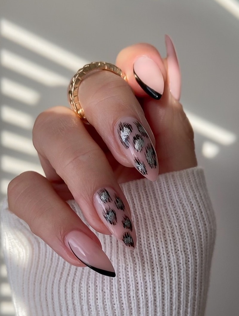 Nude nails with a black and silver cheetah print detailing and black french tips.