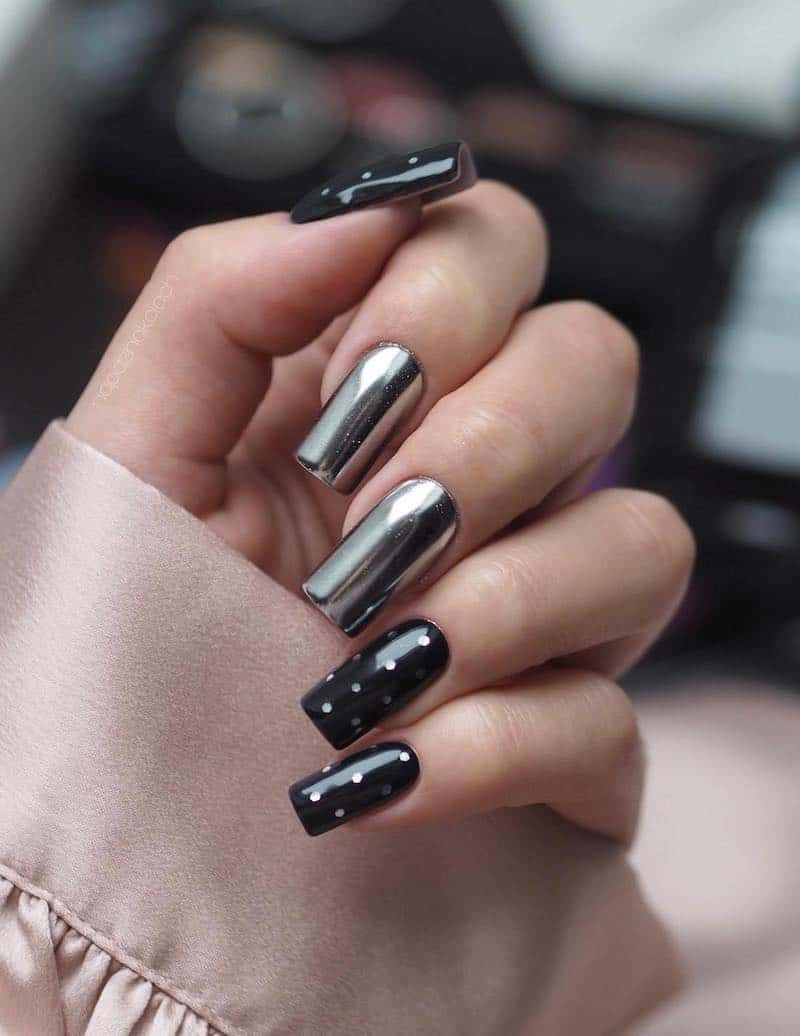 Long, square black glossy nails with silver chrome accent nails and polka dot detailing.