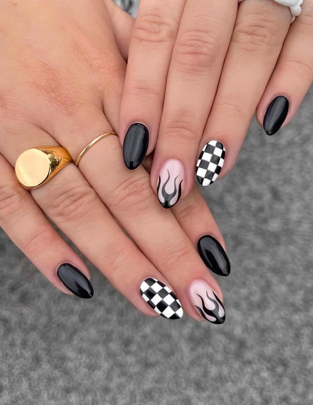 Short almond nails with solid-colored black nails, black flame nails, and white and black checkered nails