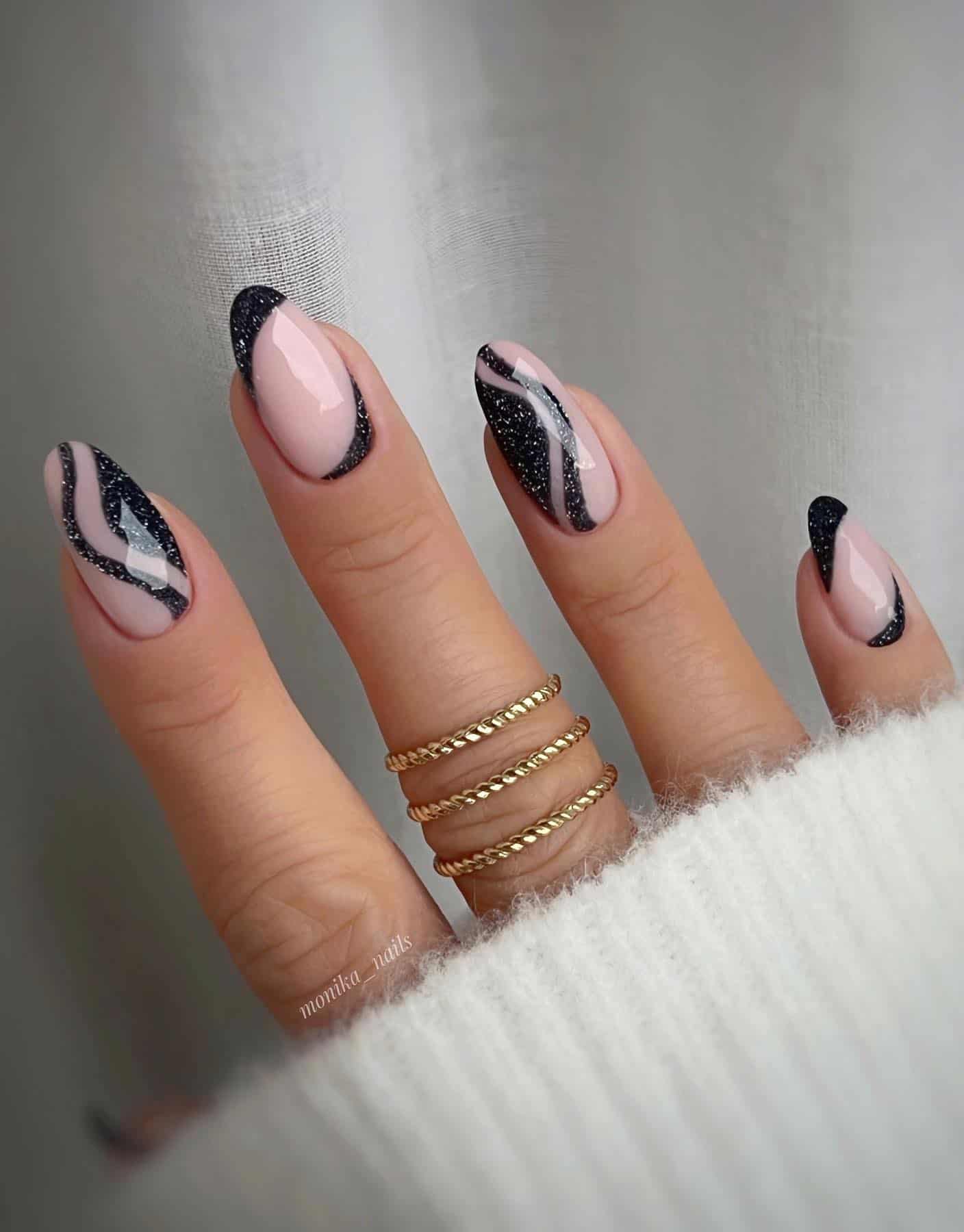 Short nude nails with glittery black wave details