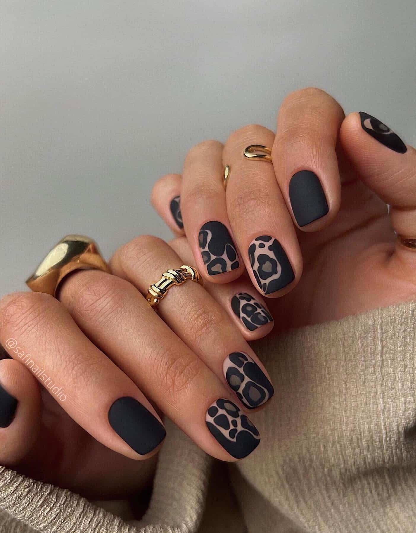 Short matte black nails with nude and black animal print accent nails
