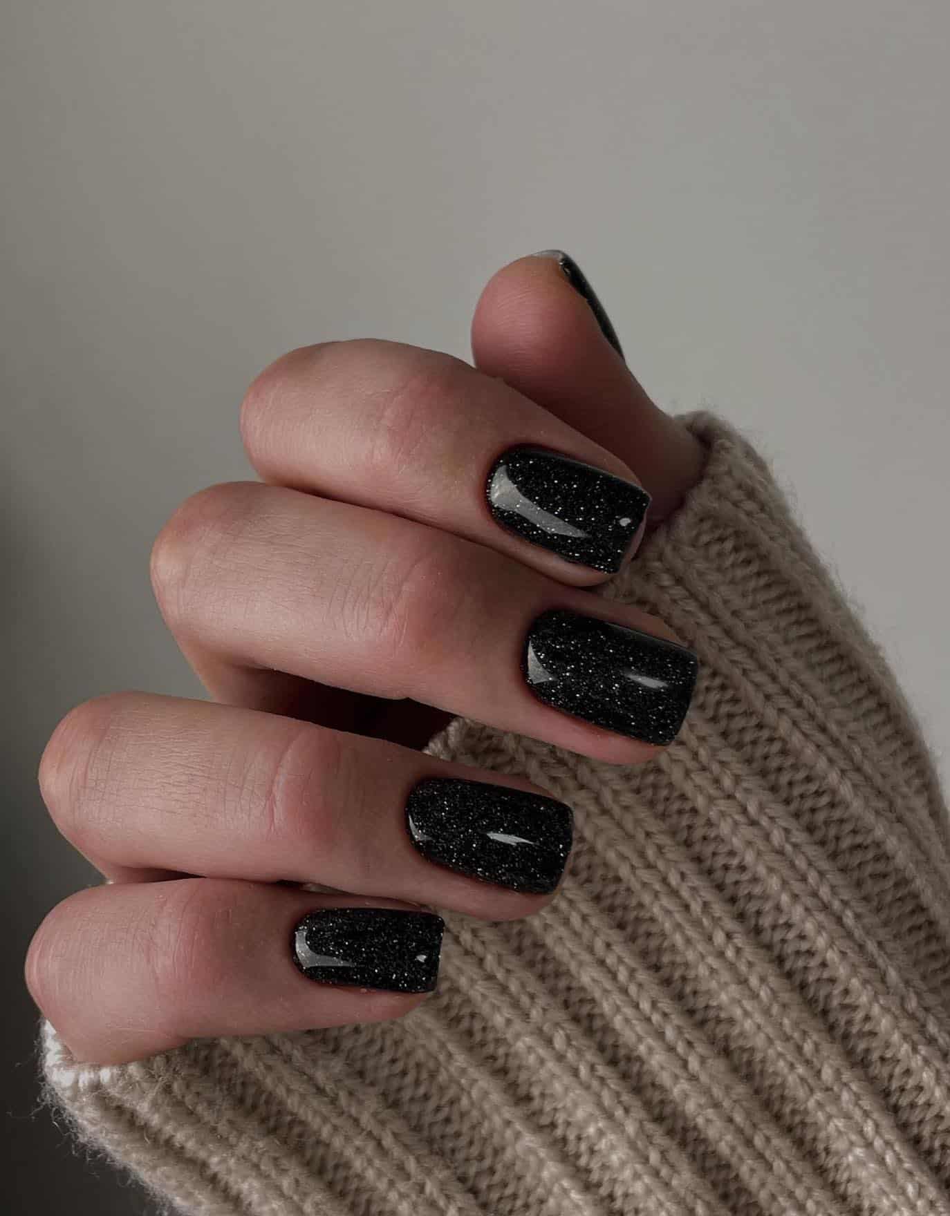 Short black glossy square nails with glitter speckles