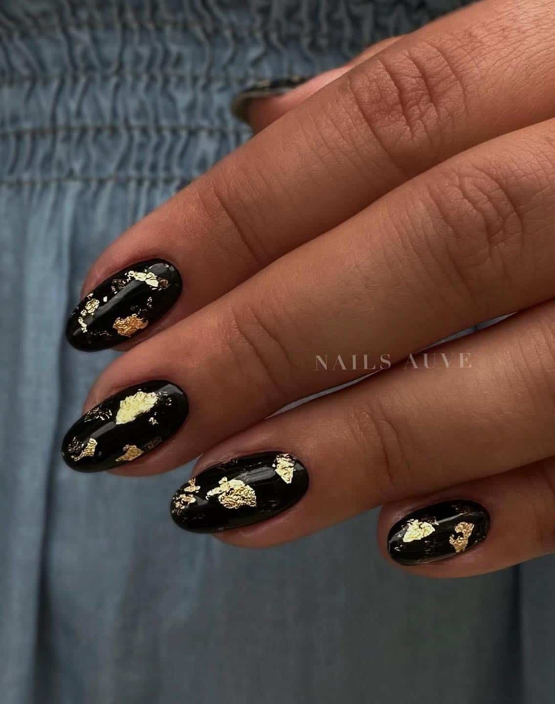 Short glossy black nails with gold flakes