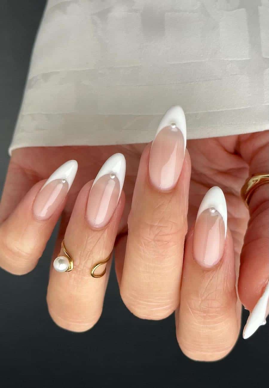 Medium length almond nails with white French tips and pearl accents