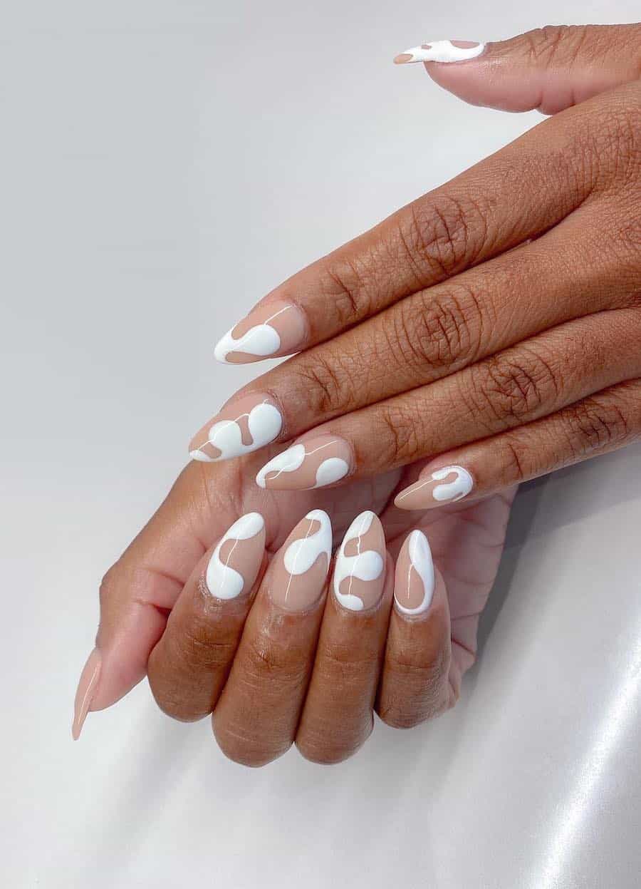 Short nude almond nails with white paint drip accents