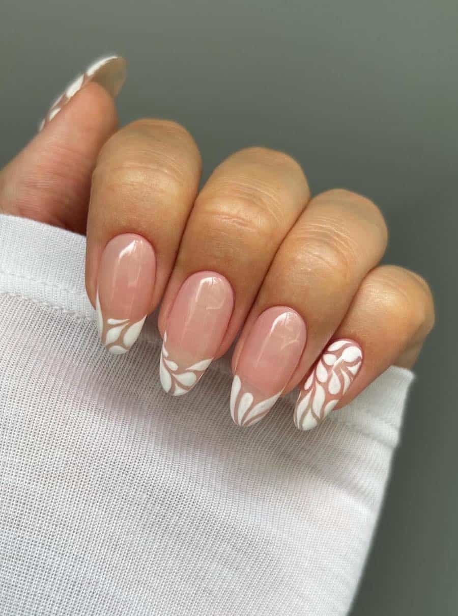 Medium length nude pink almond nails with white teardrop French tips and full art accent nails