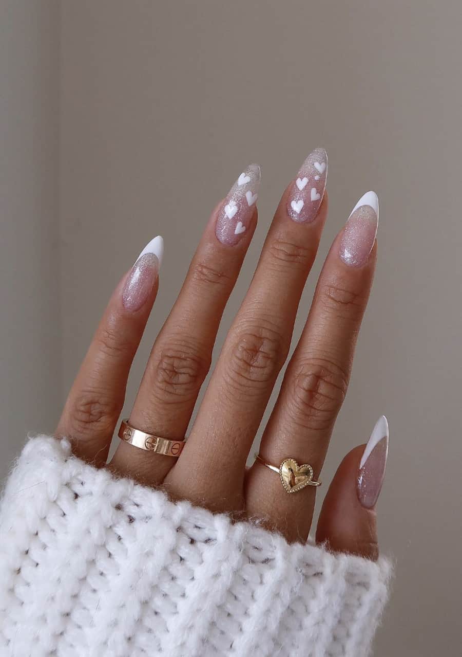 Long almond nails with nude silver glitter nails, white French tips, and heart art accent nails