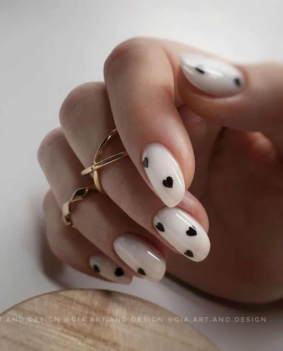 Short milky white almond nails with small black hearts