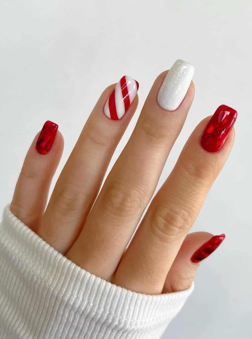 Classic red manicure with white glitter accent nails and red and white candy can details.