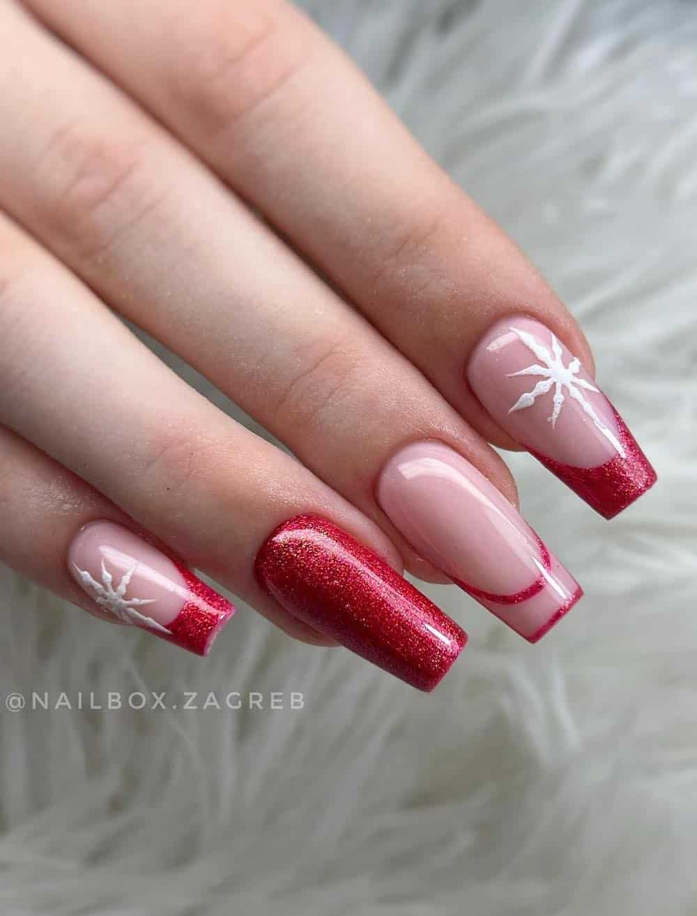 Red french tip manicure with red glitter and white snowflake detials.