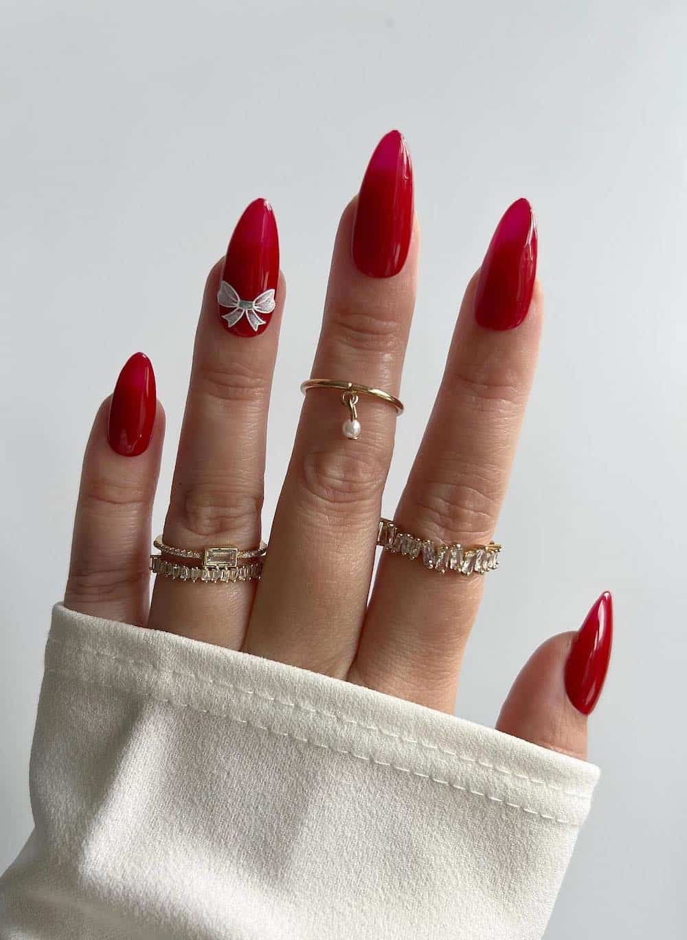 Classic red manicure with white bow accent nail.