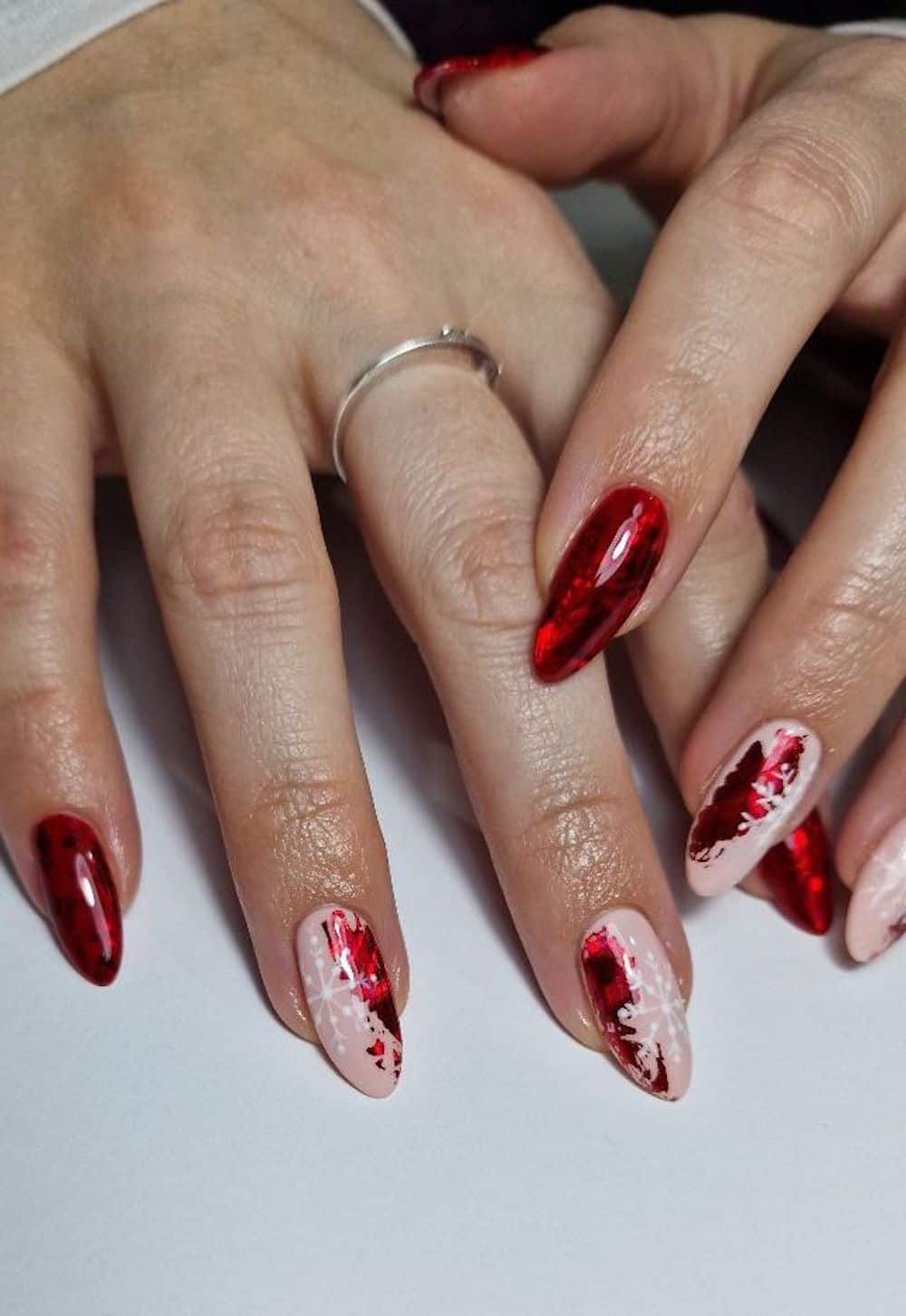 Red foil manicure with white snowflake details.