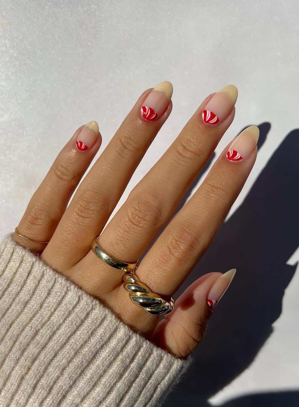 Natural manicure with red and white peppermint detail.