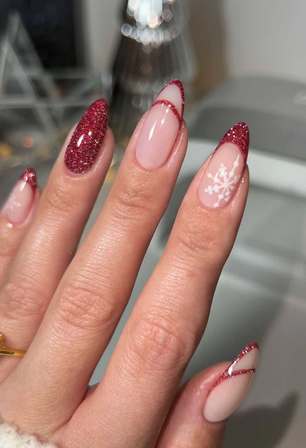 Red glitter french tip nails with snowflake detail.
