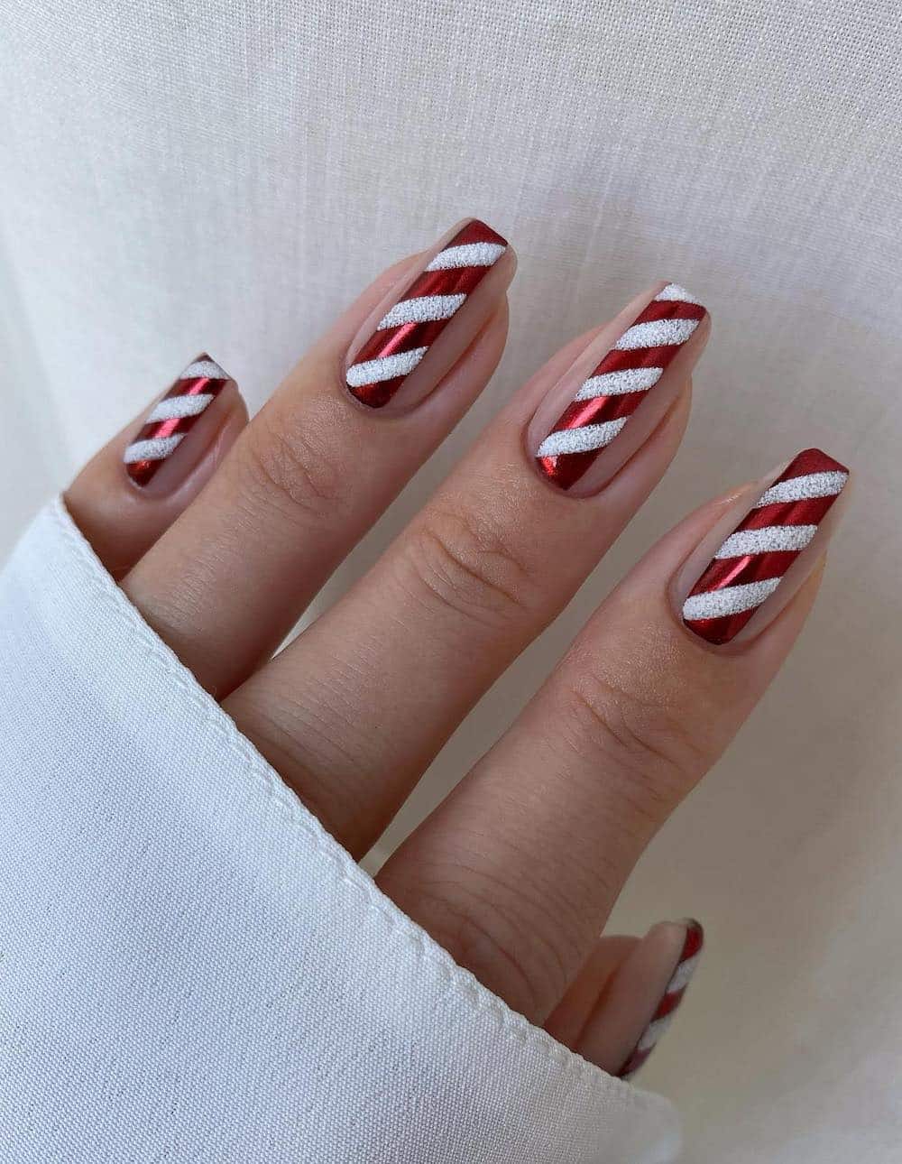 Red and white candy cane manicure with white glitter.
