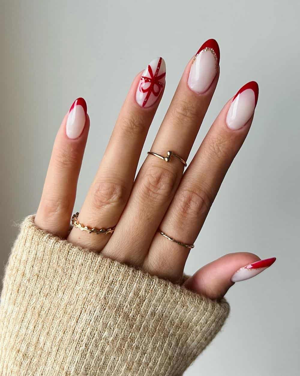 Red french tip manicure with a present bow detail nail.