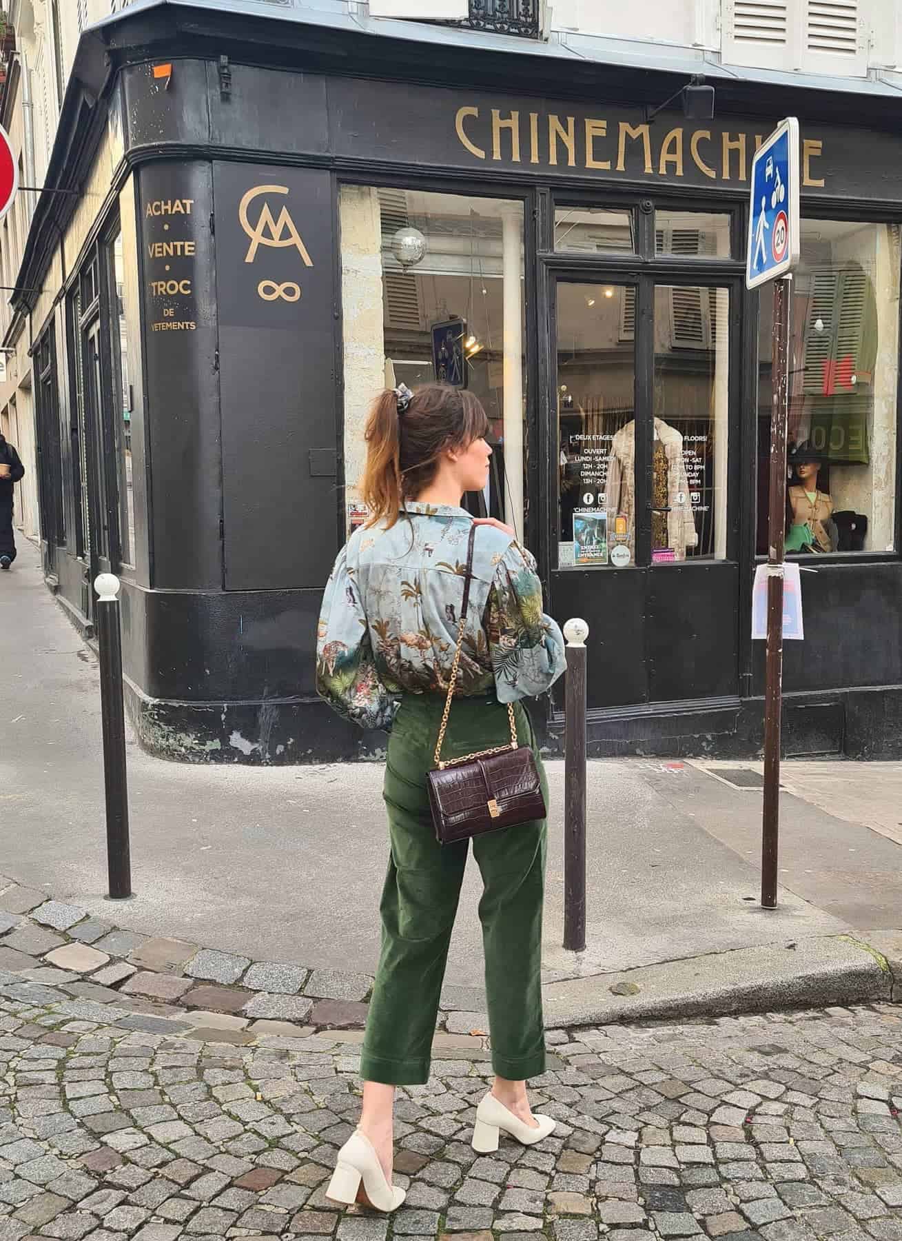Woman wearing green velvet pants and a silk button down.