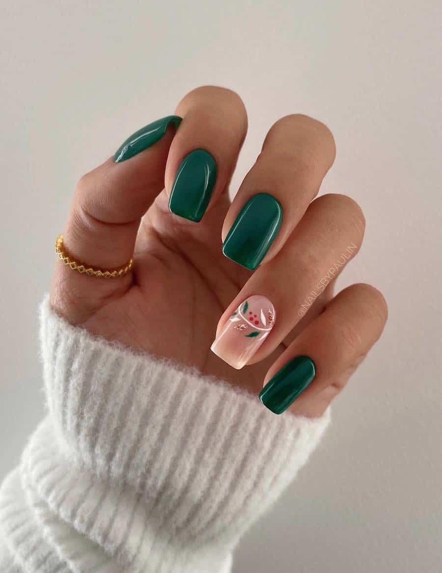 A hand with short square nails painted a deep green with one nude accent nail with colorful botanical art