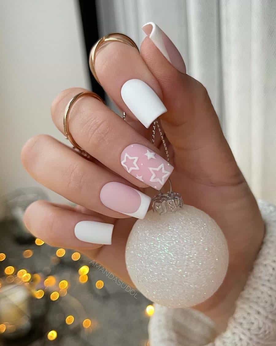 A hand with medium square nails painted a matte white with French tip accent nails and another accent nail with star art