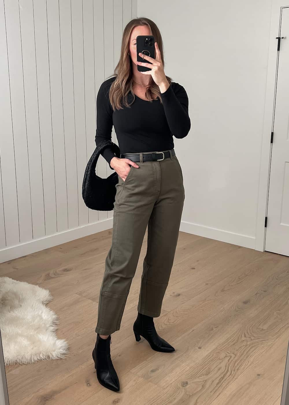 Christal wearing Everlane black top and green Barrel pants with black ankle boots