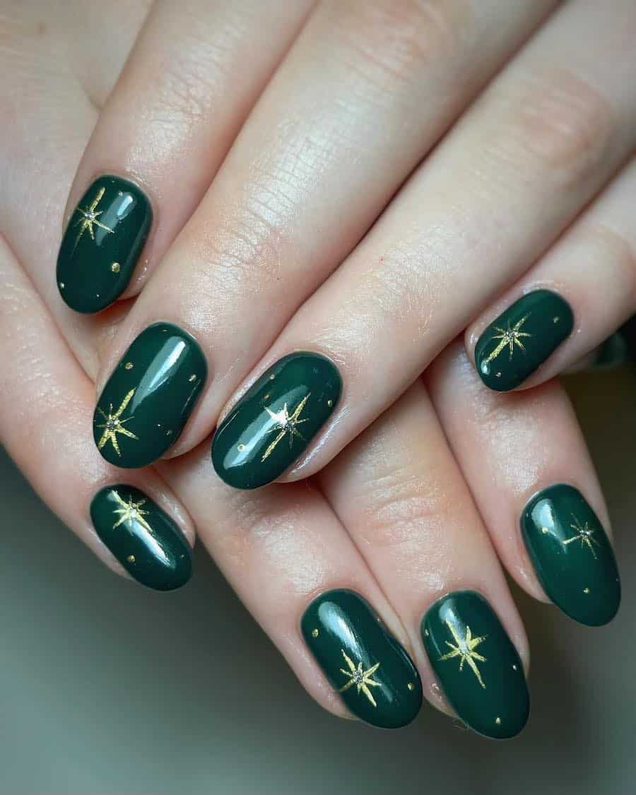 A hand with short round nails painted a glossy dark green with gold sparkle accents