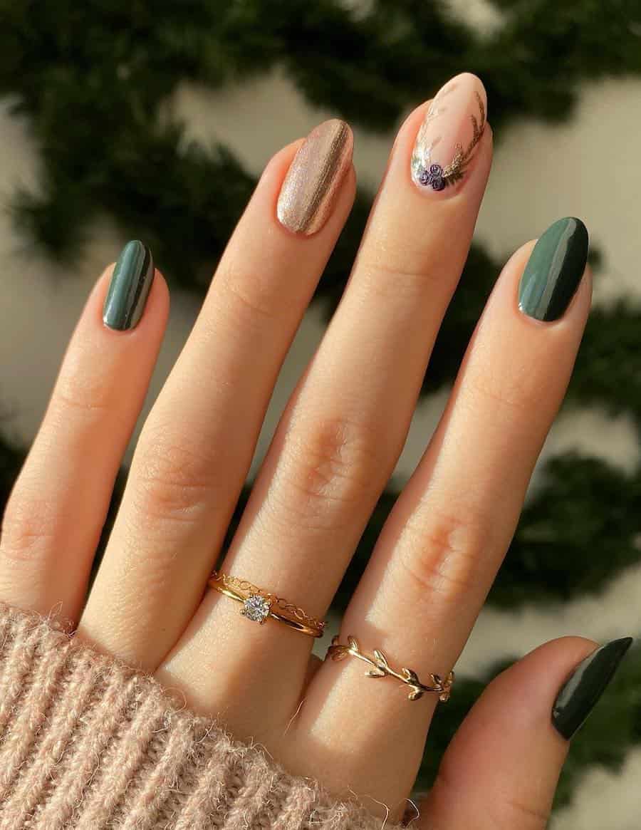 A hand with short round nails painted a solid forest green with a gold accent nail and a nude accent nail with gold wreath details