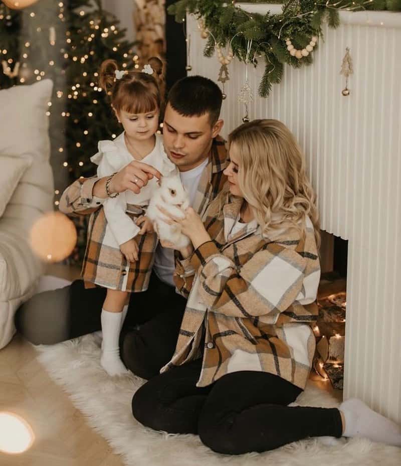 Christmas family photos with a family of three wearing brown, whit, and black plaid